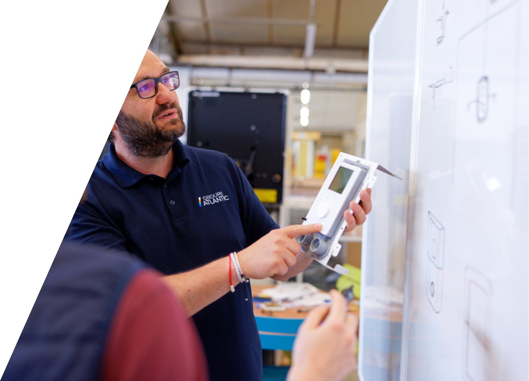 technicien regardant un tableau avec un appareil de mesure